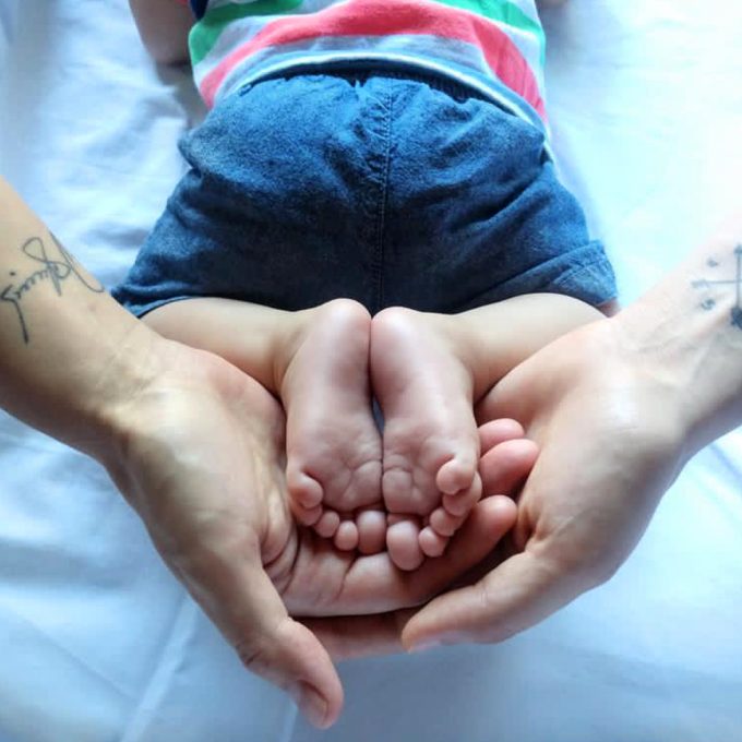 metodo-ropa-fertilizacion-in-vitro-mternidad-compartida-manos-de-dos-mamas-con-pies-de-hijo