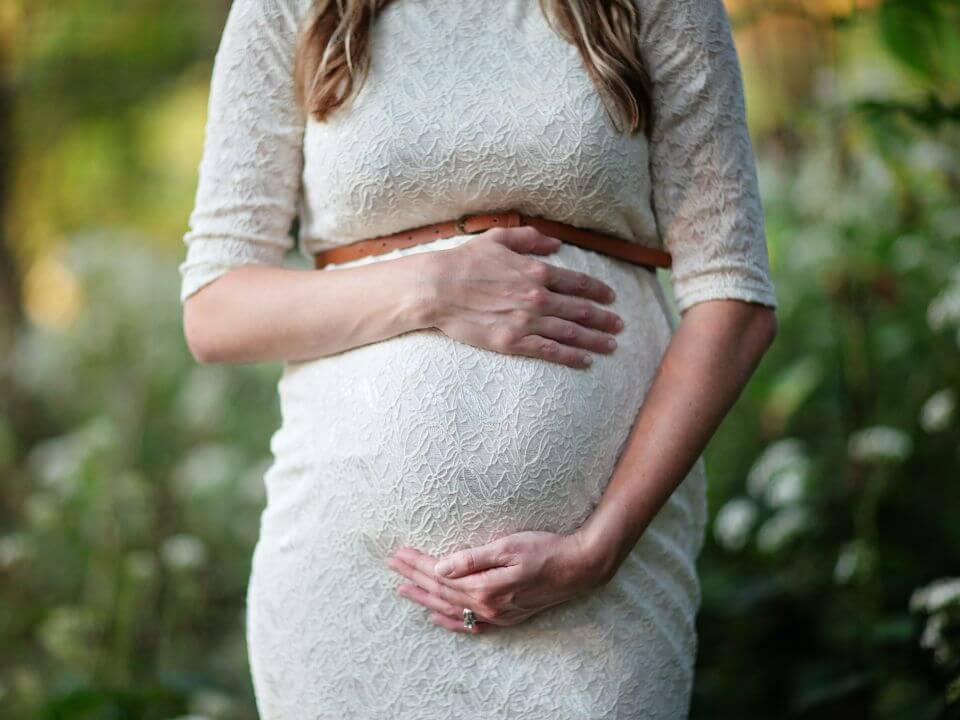 Mujer-embarazada-manos-en-el-vientre-donación-de-gametos-fertilizacion-in-vitro