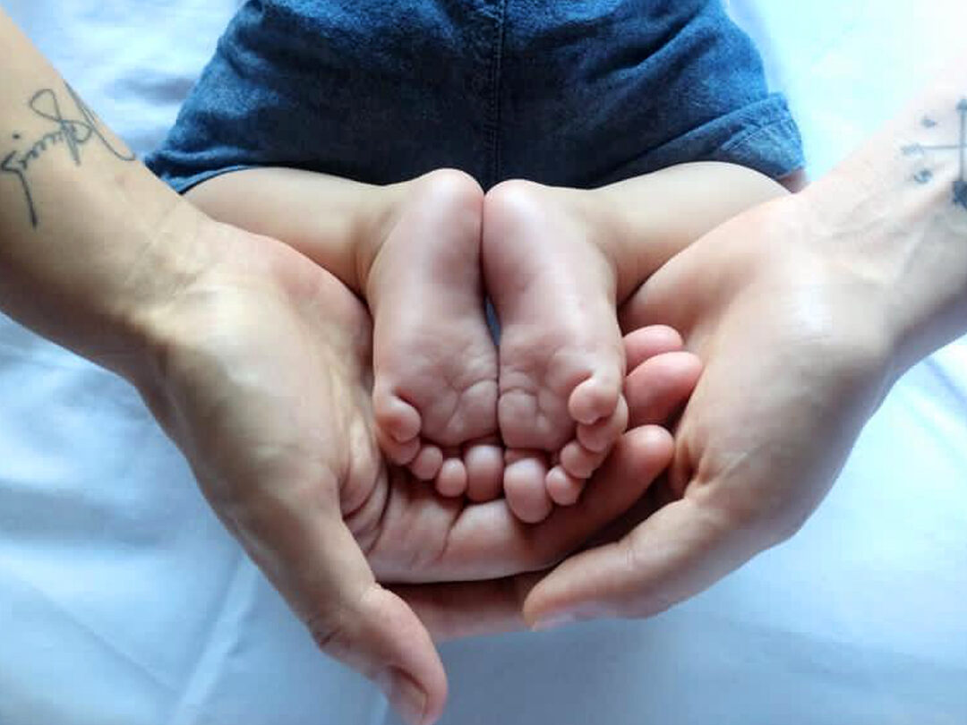 metodo-ropa-fertilizacion-in-vitro-mternidad-compartida-manos-de-dos-mamas-con-pies-de-hijo